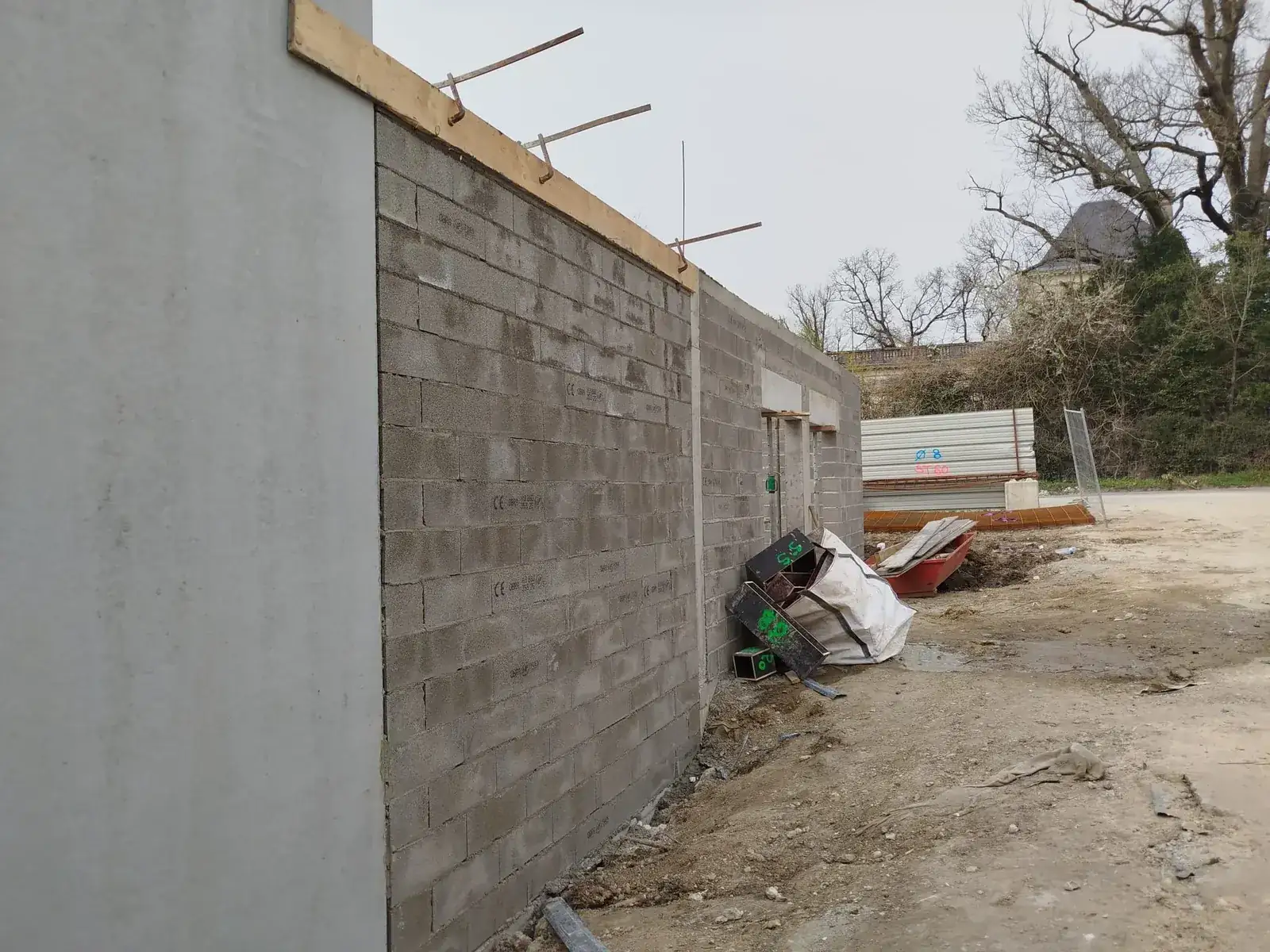 Long mur en parpaings monté avec son chaînage